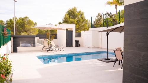 ポロップにあるAmberes apartment, a stylish villa's independent downstairs apartment with private swimming pool and terraceのパティオ(スイミングプール、パラソル付)