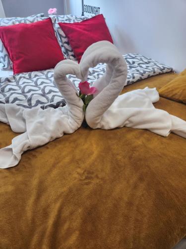 two towels shaped like hearts on a bed at WARSZAWA CENTRAL HOUSE - Studios in Warsaw with Private Jacuzzi, full access to Sauna, Gym and Billards - Studia z prywatnym Jacuzzi oraz dostępem do sauny, siłowni i bilarda in Warsaw