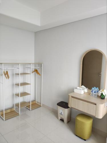 a bathroom with a desk and a yellow stool at Apartment gold coast Pik in Jakarta