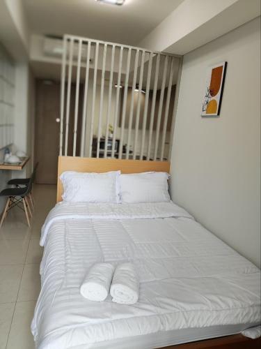 a large white bed with two white pillows on it at Apartment gold coast Pik in Jakarta