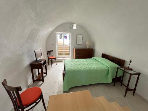 een slaapkamer met een groen bed en een tafel en stoelen bij Villa Luce in Bisceglie