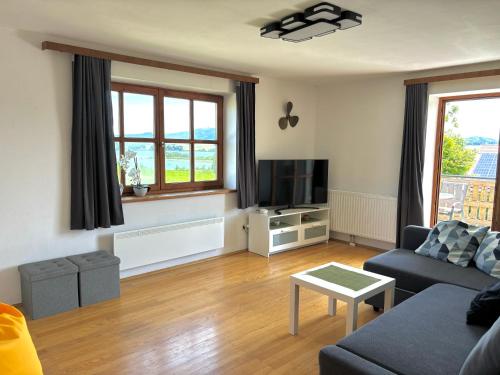a living room with a couch and a tv at Gästhaus "Seeblick" in Seekirchen am Wallersee