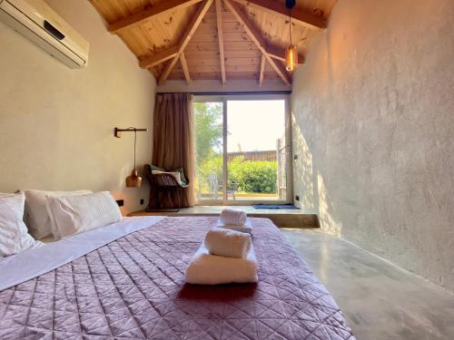 a bedroom with a large bed with a white chair on it at Kali Zoi -B&B Zakynthos in Amoudi