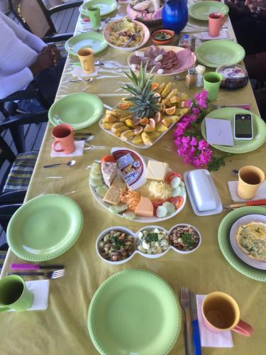 a long table with green plates and food on it at Villa Caribbean Dream in Vieux Fort