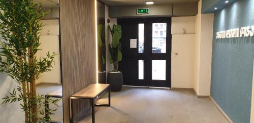 a lobby with a door and a bench and plants at Love Journey Tbilisi in Tbilisi City