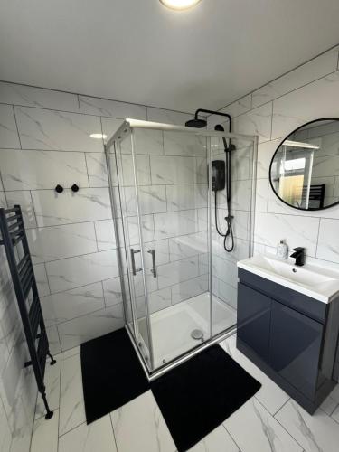 a bathroom with a glass shower and a sink at Newly built one bedroom flat in Kidlington, Oxfordshire in Kidlington