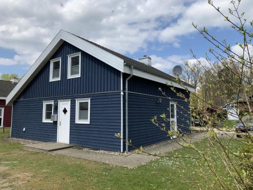 ein blaues Haus mit einer weißen Tür in der Unterkunft Holiday home Seeidyll am D mmer See D mmer in Dümmer