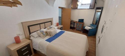 ein Schlafzimmer mit einem großen weißen Bett in einem Zimmer in der Unterkunft Apartamentos Fuente Nueva II in Cáceres