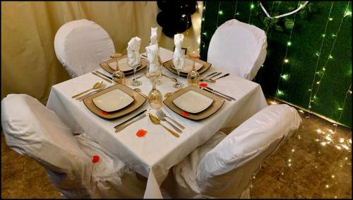 a table with a white table cloth and white chairs at Hôtel La Belle Etoile & SPA in Saly Portudal