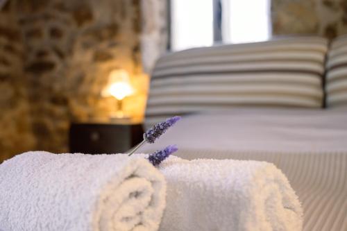 a towel on a bed with a toothbrush at Messinian Stone House in Messini