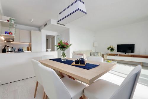 a dining room and living room with a table and chairs at Portopiccolo Apartments in Sistiana