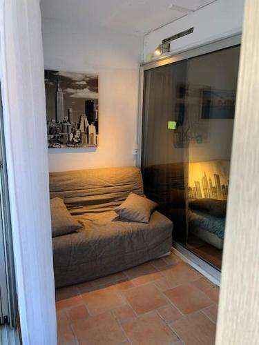 Cette chambre comprend un lit et un canapé. dans l'établissement Studio centre port, Cap d'Agde, au Cap d'Agde