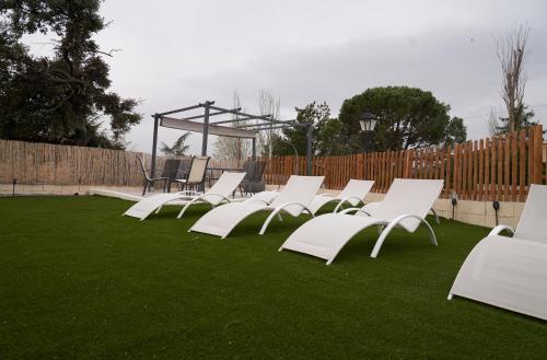 a group of white chairs sitting on the grass at VILLA Formonte in Los Ángeles de San Rafael