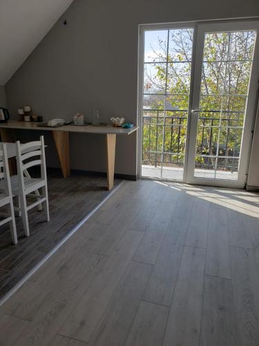 an empty room with a table and a large window at Apartment Natura in Tbilisi City