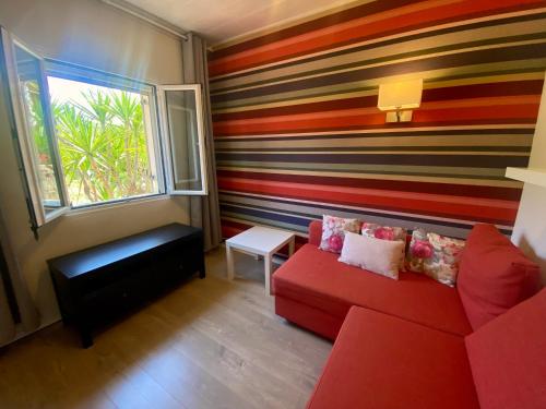 a living room with a red couch and a striped wall at Kali Zoi -B&B Zakynthos in Amoudi