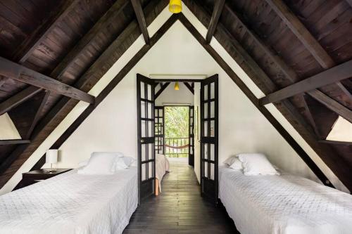 2 camas en un ático con techos de madera en Villa Linderhof, en Montenegro