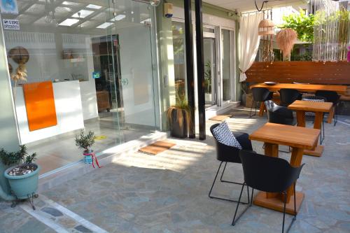 a patio with a table and chairs in a building at Virginia Rooms in Olympiaki Akti