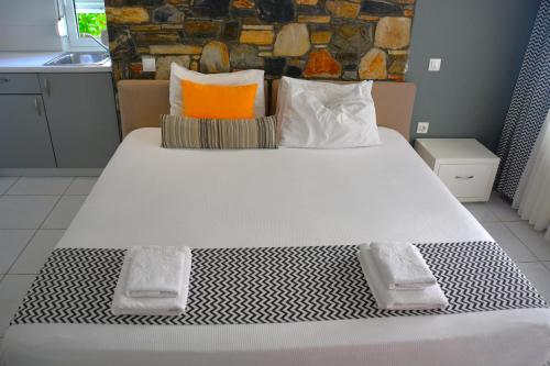 a bedroom with a large bed with two pillows at Virginia Rooms in Olympiaki Akti