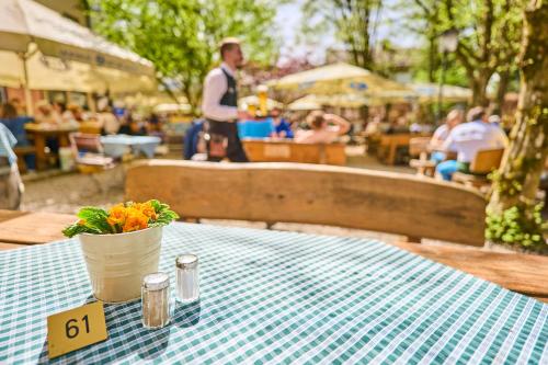 a table with a vase of flowers on top at Hotel Waldgasthof Buchenhain in Baierbrunn