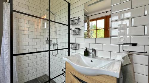 a white bathroom with a sink and a mirror at Zöld 21 Cottage in Őrtilos
