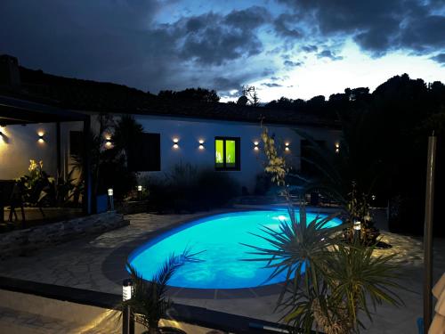 una casa con piscina por la noche en Partie de villa moderne avec piscine En option jaccuzi dans espace détente indépendant, en Villeneuve