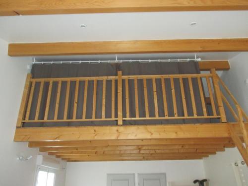 a loft bed in a room with wood at Studio entre terre et mer in Saint-Romain-de-Benet