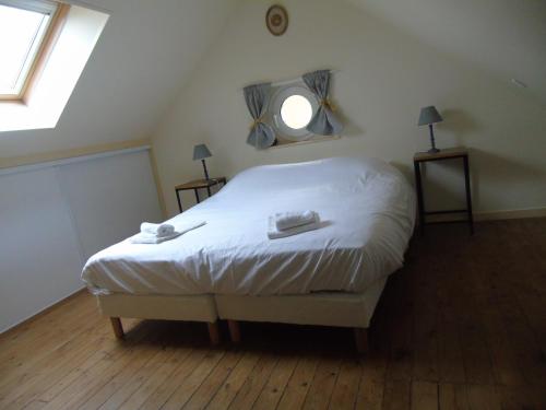 une chambre avec un lit avec des draps blancs et une fenêtre dans l'établissement Petit Argousier, à Cambron