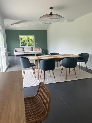 une salle à manger avec une table, des chaises et un canapé dans l'établissement Chambres doubles dans maison juste refaite à neuf, à Vertou