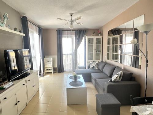 - un salon avec un canapé et une télévision dans l'établissement Apartamento Puerto Deportivo Almerimar, à Almerimar