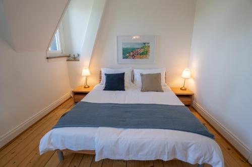 ein Schlafzimmer mit einem großen weißen Bett mit zwei Lampen in der Unterkunft Charmante Altbauwohnung am Rhein in Basel