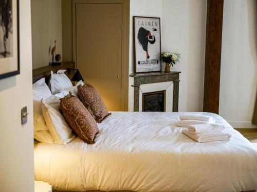 a bedroom with a bed with white sheets and a fireplace at Maison d'hôtes - Stay and Cook in Annonay