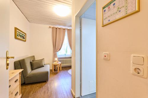 a living room with a chair and a window at Hotel Waldgasthof Buchenhain in Baierbrunn