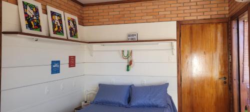 un letto in una piccola camera con cuscini blu di Apartamento Cobertura com vista panorâmica a Pelotas