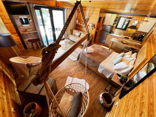 an aerial view of a room with a bed and swing at Wooden Summer House in Mantoúkion