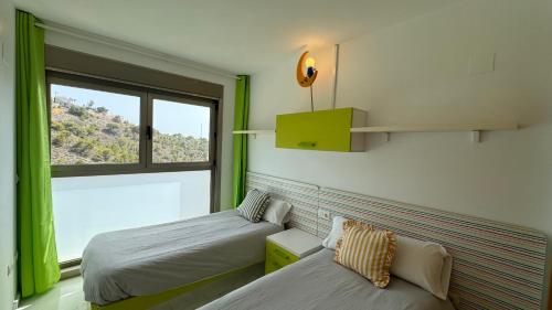 2 Betten in einem Zimmer mit Fenster in der Unterkunft 2-bedroom apartment in Torre Lúgano 58 in Benidorm