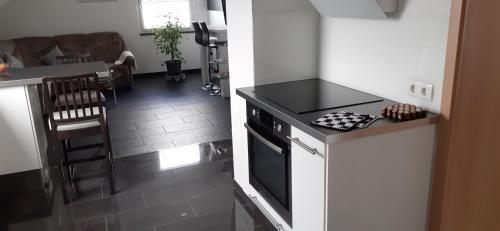 シュタイネンにあるFerienwohnung Belchenblickのコンロ付きのキッチン リビングルームの隣にトップオーブン