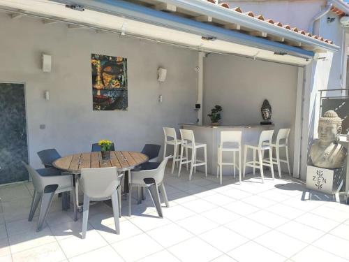 un patio avec une table, des chaises et un bar dans l'établissement Villa familiale en Provence, à Beaucaire