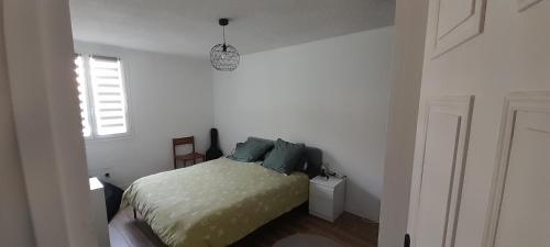 une chambre blanche avec un lit et une fenêtre dans l'établissement La Briancelle, à Briançon