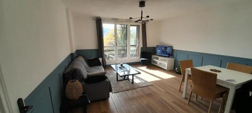 un salon avec un canapé et une table dans l'établissement La Briancelle, à Briançon