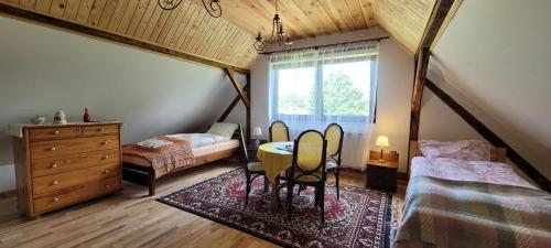 1 dormitorio con mesa, 2 camas y ventana en Gryglówka Noclegi en Zembrzyce