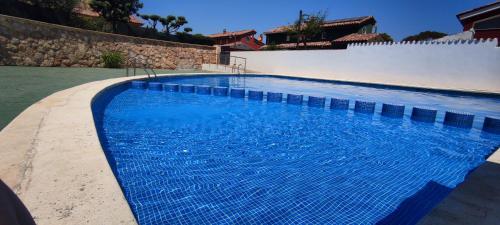a large swimming pool with blue water at Casa El Niuet PeñiscolaPeniscola ideal familias in Peniscola