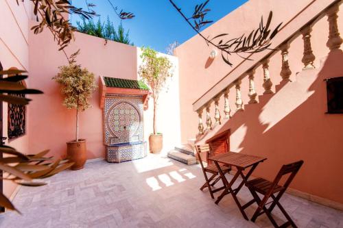 un patio avec deux chaises et une table à côté d'un bâtiment dans l'établissement Zine Villa Guest House, à Marrakech