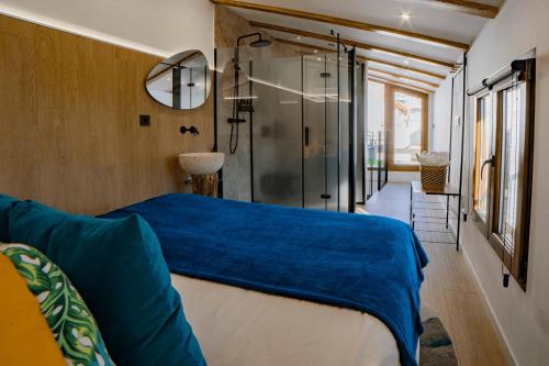 a bedroom with a bed and a glass shower at Los parajes de Alcalá in Alcalá del Júcar
