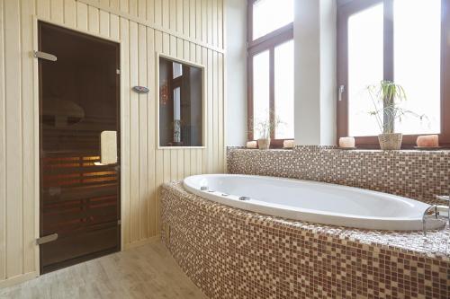 a bathroom with a large tub in a room with windows at Wellness Apartment De Luxe in Liberec