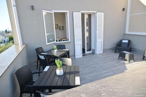a balcony with two tables and chairs and a table at Da 'Nfacci Affittacamere in Carini