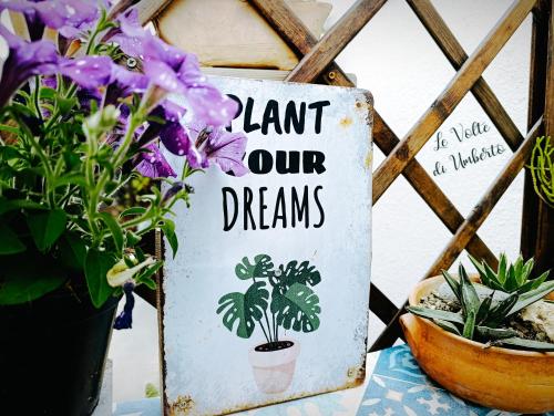 a sign that says plant our dreams next to flowers at Le volte di Umberto in Sogliano Cavour