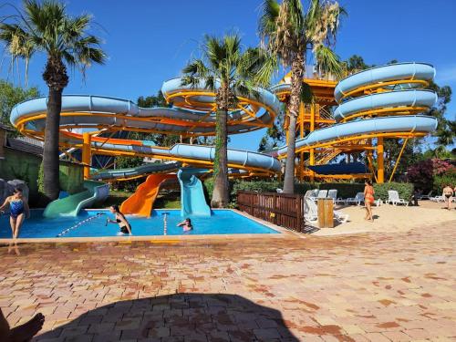 - un parc aquatique avec un toboggan et des personnes y séjournant dans l'établissement Rooftop Villeneuve, à Villeneuve-Loubet