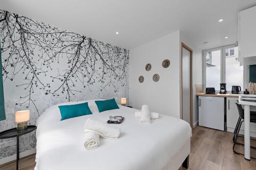 1 dormitorio con 1 cama blanca y cocina en L'escale normande - Terrasse - Gare, en Rouen