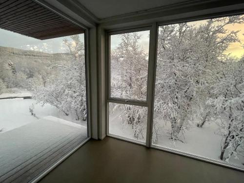 a window with a view of snow covered trees at Platinum VIP - Aurora luxury house in Tromsø