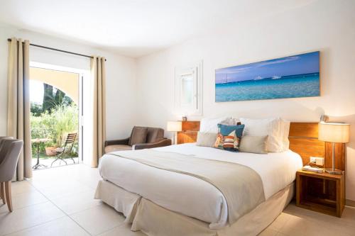 um quarto com uma cama e uma sala de estar em Hotel La Garbine em Saint-Tropez